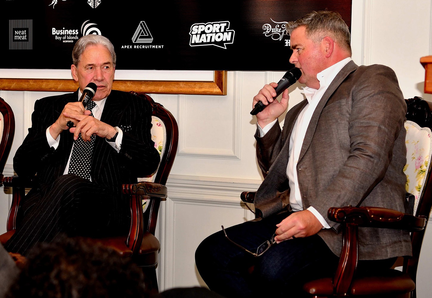 Andrew Saville and a panel speaker on stage at the Game Changers Forum